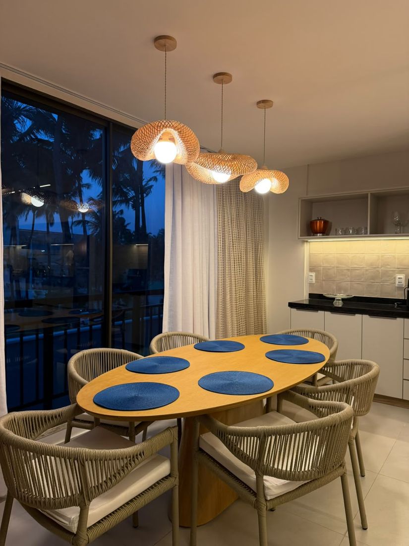 Jantar com pendentes de fibra e vista para os coqueiros