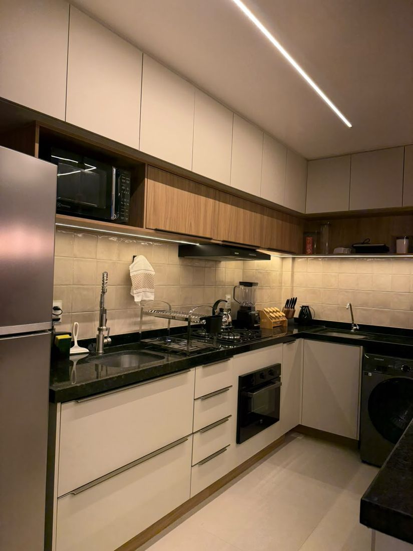 Cozinha com marcenaria planejada e iluminação sob os armários